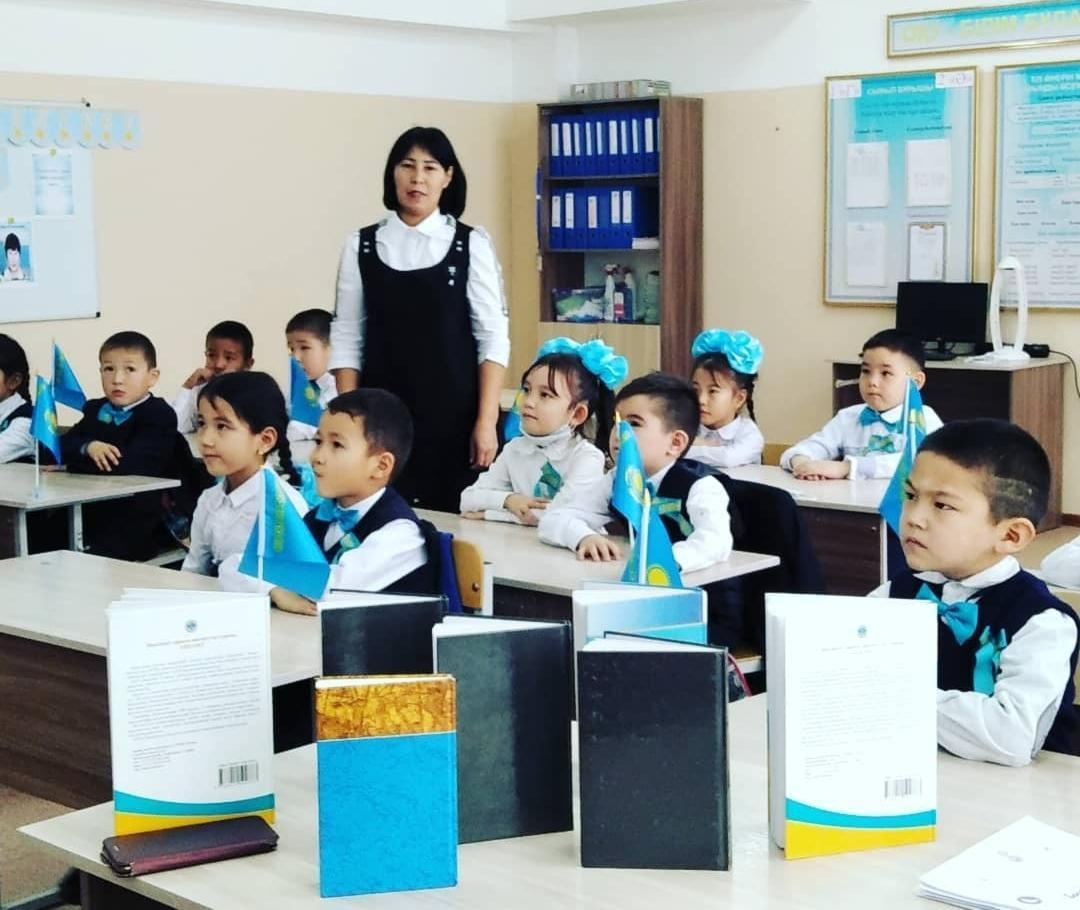 1"Ә" сыныбы Тәуелсіздік күніне арналған тәрбие сағаты барысында сынып жетекшісі Анар апай кітаптар көрмесімен таныстырып өтуде.